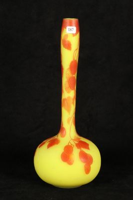 an orange and yellow vase sitting on top of a black table