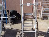 many ladders that are sitting outside on the ground