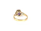 a close up of a gold ring with a purple stone