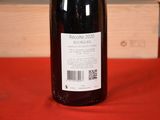 a bottle of wine sitting on a table next to a wooden box