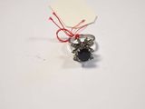 silver ring with black stone and red string on white surface