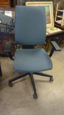 une chaise de bureau bleue qui se trouve dans une pièce