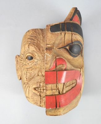 an image of a wooden mask with a red and black face