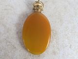 un pendentif en agate orange muni d'une bélière plaquée or