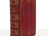 an old red book with gold trimmings on the front of it
