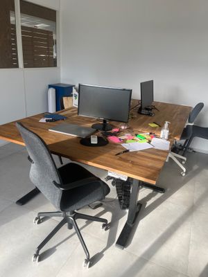 un bureau avec deux ordinateurs et une chaise dans la chambre