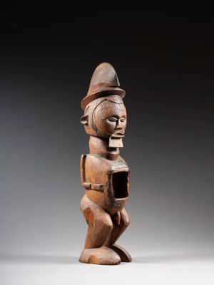 une statue en bois d'une femme avec un chapeau sur la tête