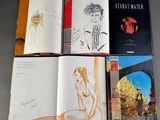 many books that are open on a table