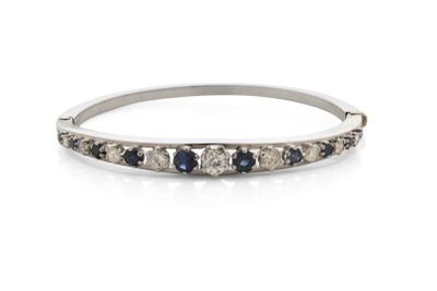 gros plan d'une bague en diamant et saphir sur une surface blanche