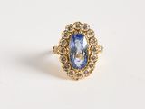 a gold ring with a blue stone surrounded by white diamonds