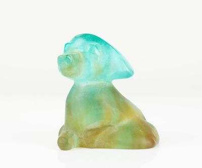 a glass figurine of a cat sitting on a white surface
