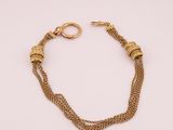 un bracelet en chaîne d'or avec deux boucles et un fermoir, sur fond blanc