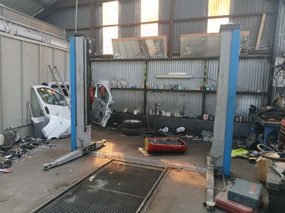 une photo d'un garage où une voiture est en cours de réparation