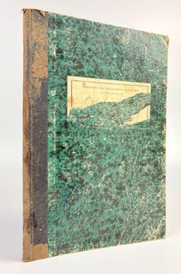 an old book with a green cover sitting on top of a white surface
