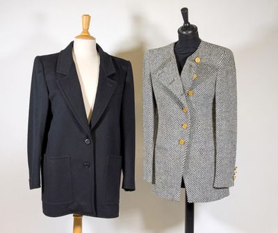 two coats on a mannequin stand in front of a white wall