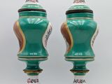 pair of green and gold vases with floral designs on them