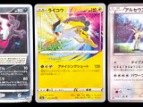 Trois cartes Pokémon sont posées sur une surface noire