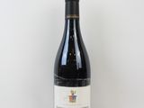 la bouteille de vin rouge est posée sur une surface blanche