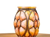 a glass vase with a pattern on it sitting on a table
