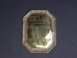 an image of a gold plate with a picture of a man on it
