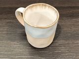 une tasse à café posée sur une table au plateau en bois