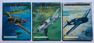 trois livres posés sur une table blanche, avec une image représentant un avion et un avion