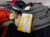 a backpack, a calculator, a pair of shoes, and a book on a bed