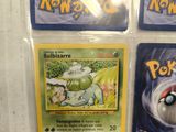 four different pokemon cards on display in a display case