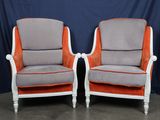 une paire de fauteuils rembourrés orange et gris sur fond bleu