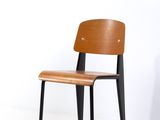 une chaise en bois avec des pieds noirs et une assise en bois
