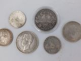 six different types of coins on a white surface