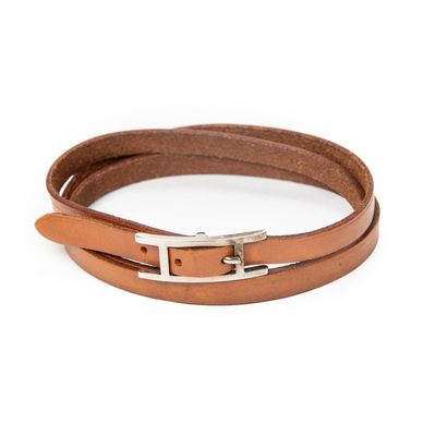a close up of a brown leather bracelet on a white background