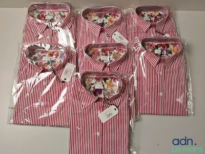 quatre t-shirts rayés rouges et blancs dans des sacs en plastique posés sur une table