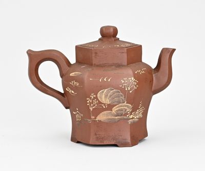 une théière marron ornée d'un motif