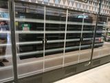 un homme en train de prendre une photo d'un réfrigérateur dans un magasin