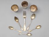 Plusieurs cuillères et tasses en argent sont disposées en cercle