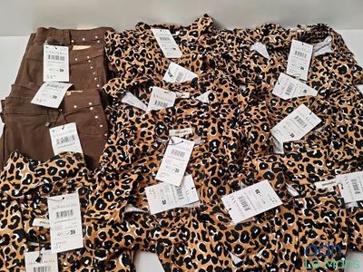 Plusieurs paires de pantalons à imprimé léopard sont posées sur une surface blanche