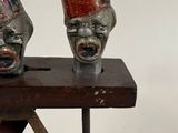 two masks on a wooden stand with a white background