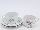 two cups and saucers are sitting on a white surface