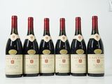 six bouteilles de vin sont alignées sur une table