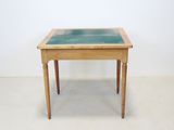 a small wooden table with a glass top on it