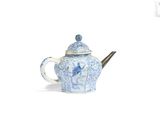une théière bleue et blanche contenant une cuillère