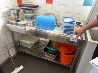 a man that is standing in a kitchen with a mop and buckets