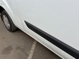 a white van parked in a parking lot next to a building