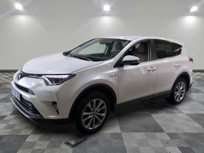 une Toyota RAV blanche garée dans une pièce au sol en damier
