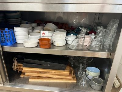 de nombreux bols et casseroles sur l'étagère de la cuisine