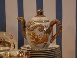 a tea pot sitting on top of a stack of plates