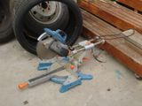 a machine that is sitting on the ground next to a pile of wood
