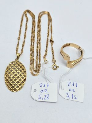 three gold necklaces and a ring with a price tag