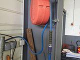 une photo représentant une borne d'incendie et un tuyau d'arrosage dans un garage